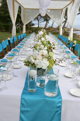 long dinner table set with white orchids
